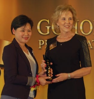 At right, Marilyn Leslie, president of MiniCo Asia Ltd., accepts the Best Storage award from Viola Cheng, director of the New World Club, during the GoHome Awards 2013 ceremony on Oct. 29.
