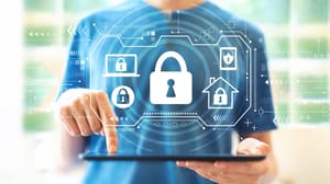 A man typing on a keyboard with a virtual screen of security icons above it A man typing on a keyboard with a virtual screen of security icons above it