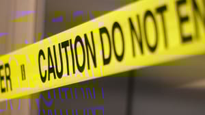 An image of caution tape stretched across with a building in the background. An image of caution tape stretched across with a building in the background.