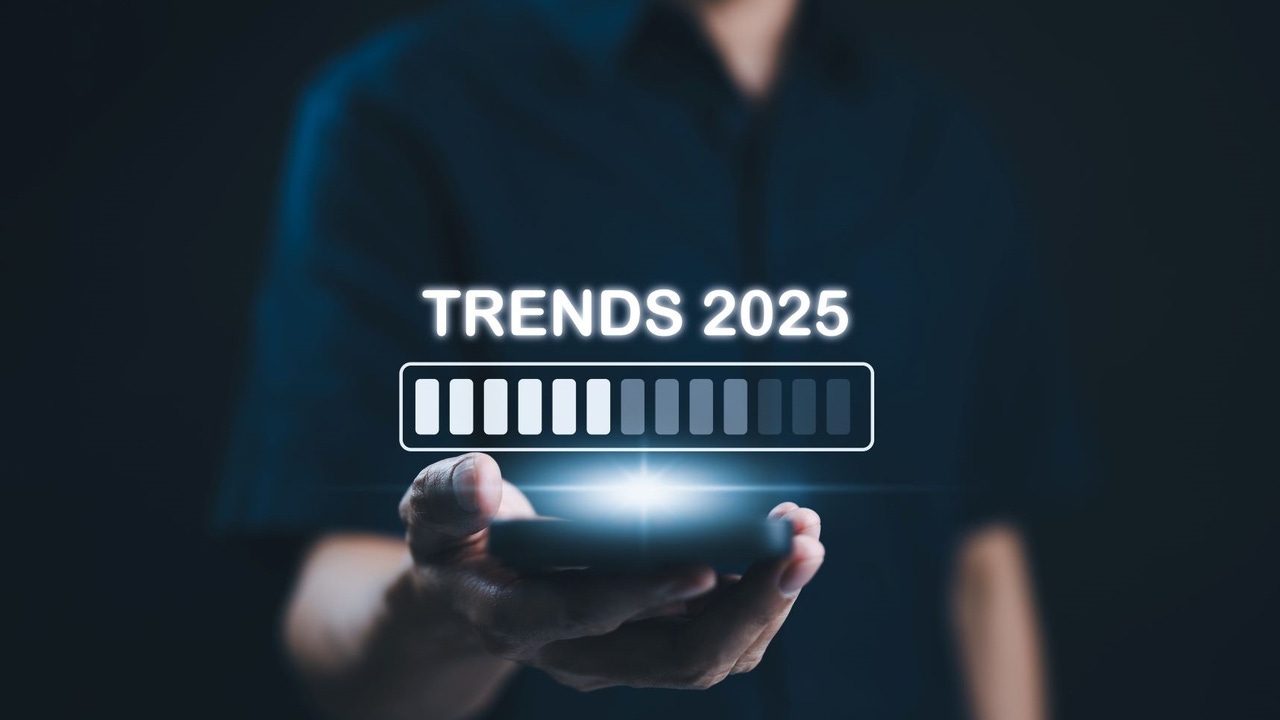 A man holding a smart phone with the words 2025 trends above it A man holding a smart phone with the words 2025 trends above it