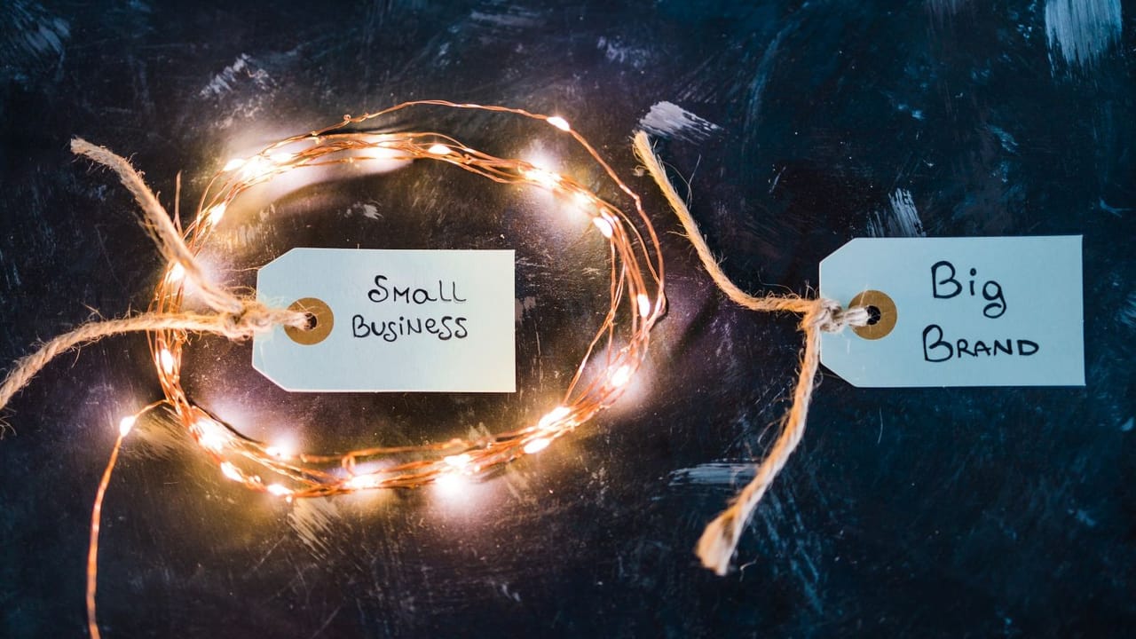 Two product tags with one marked small business and the other marked big brand Two product tags with one marked small business and the other marked big brand