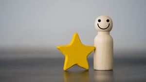 An image of a wooden person figure next to a bright yellow star An image of a wooden person figure next to a bright yellow star
