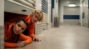 A man and woman peeking out from a self-storage unit and looking down the hallway A man and woman peeking out from a self-storage unit and looking down the hallway