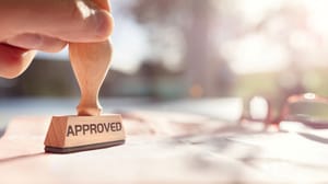 Person stamping approved stamp on a document Person stamping approved stamp on a document