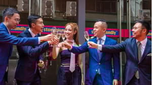 Five people toasting champagne in front of a building Five people toasting champagne in front of a building