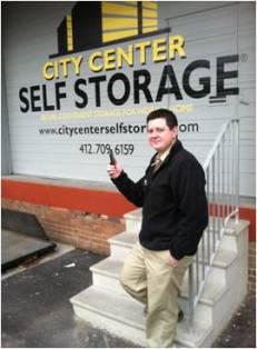 The author with his iPhone, standing in front of storefront, which was partially funded by a grant from the city. 