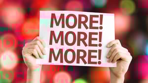 An image of a person holding a sign with the words More More More An image of a person holding a sign with the words More More More