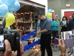 Robert Madsen cuts the ribbon of the donated unit.