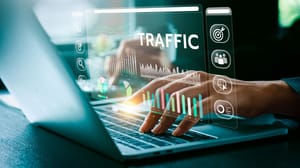 Someone typing on a laptop with a virtual graphic about web traffic hovering above it Someone typing on a laptop with a virtual graphic about web traffic hovering above it