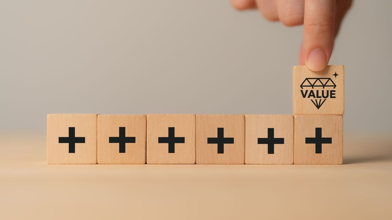 An image of square tiles with plus signs with a hand holding a tile with a crown An image of square tiles with plus signs with a hand holding a tile with a crown