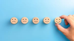 An image of several round wooden circles with faces that move from mad to happy An image of several round wooden circles with faces that move from mad to happy