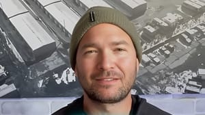 A man wearing a hat looking into a camera and smiling A man wearing a hat looking into a camera and smiling