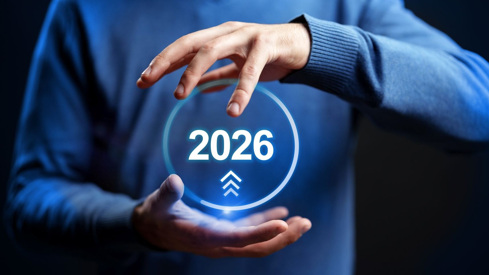 An image of a person's hands around a ball with the 2026 date in it