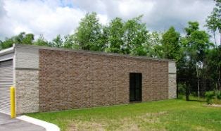A parapet wall like this one at Self-Storage of Brookfield in Wisconsin extends beyond the roofline to create the illusion of a more substantial building. In this example, faux windows and a combination of brick/stone panel have also been applied to the end wall. 