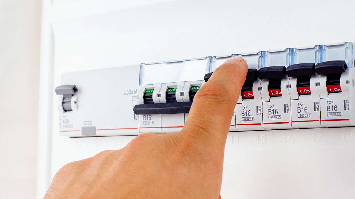 An extended index finger touching a dishwasher control button.