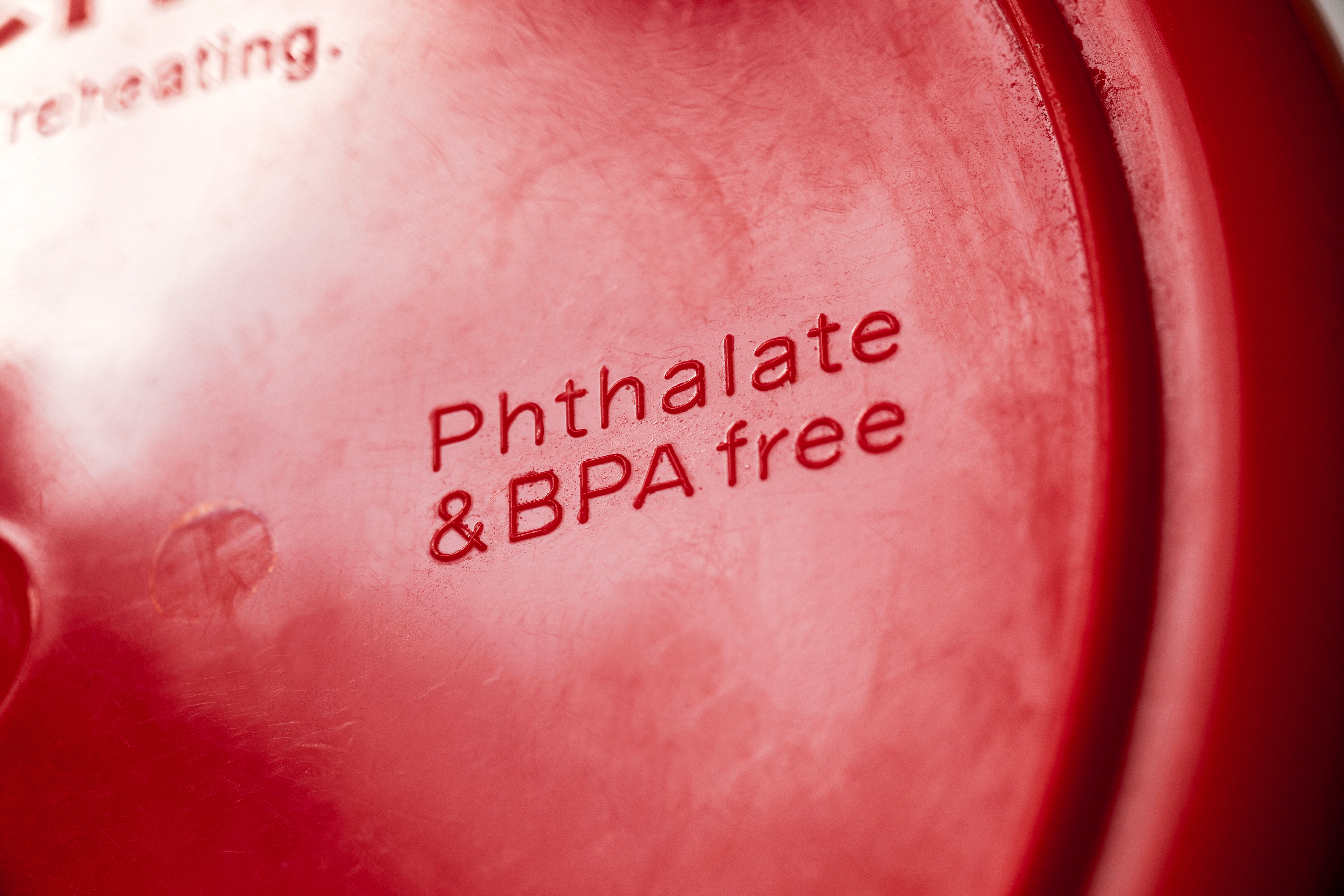A red container lid with embossed text reading "Phthalate & BPA free" in focus.