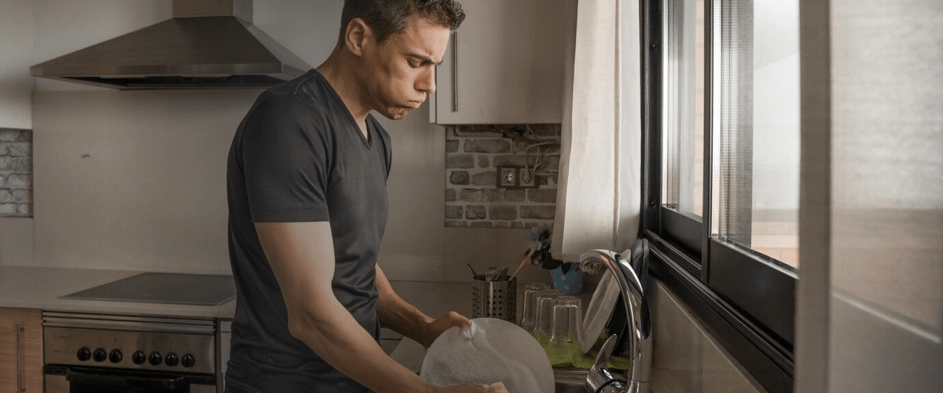 Pessoa lavando pratos em uma cozinha moderna com um texto sobreposto sobre lavagem de pratos sem estresse.