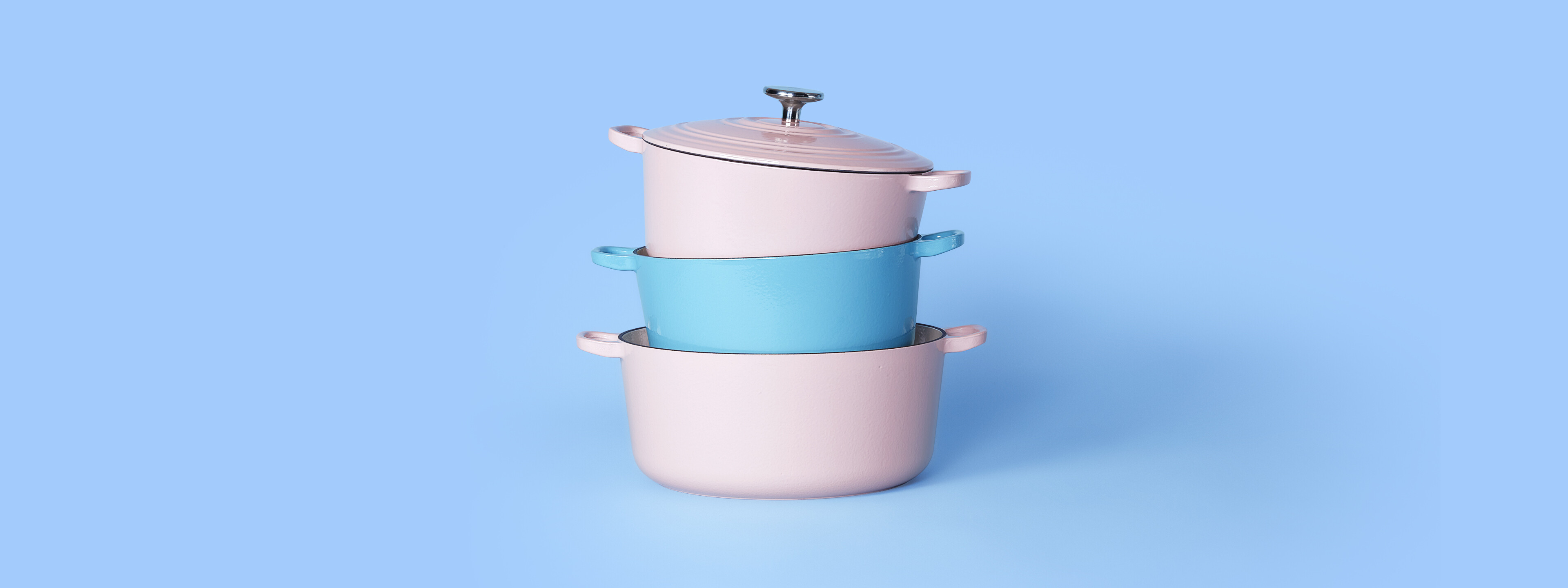 Roze en blauwe pannen gestapeld voor een blauwe achtergrond