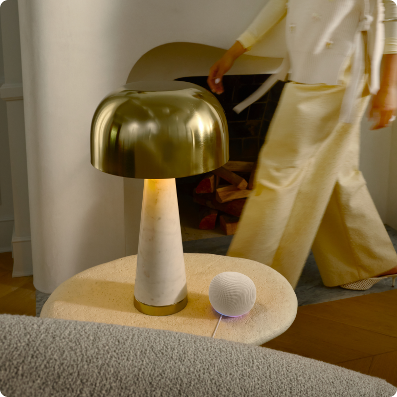 Moderne-lamp-met-gouden-kap-vrouw-in-lichte-kleding-ernaast.png