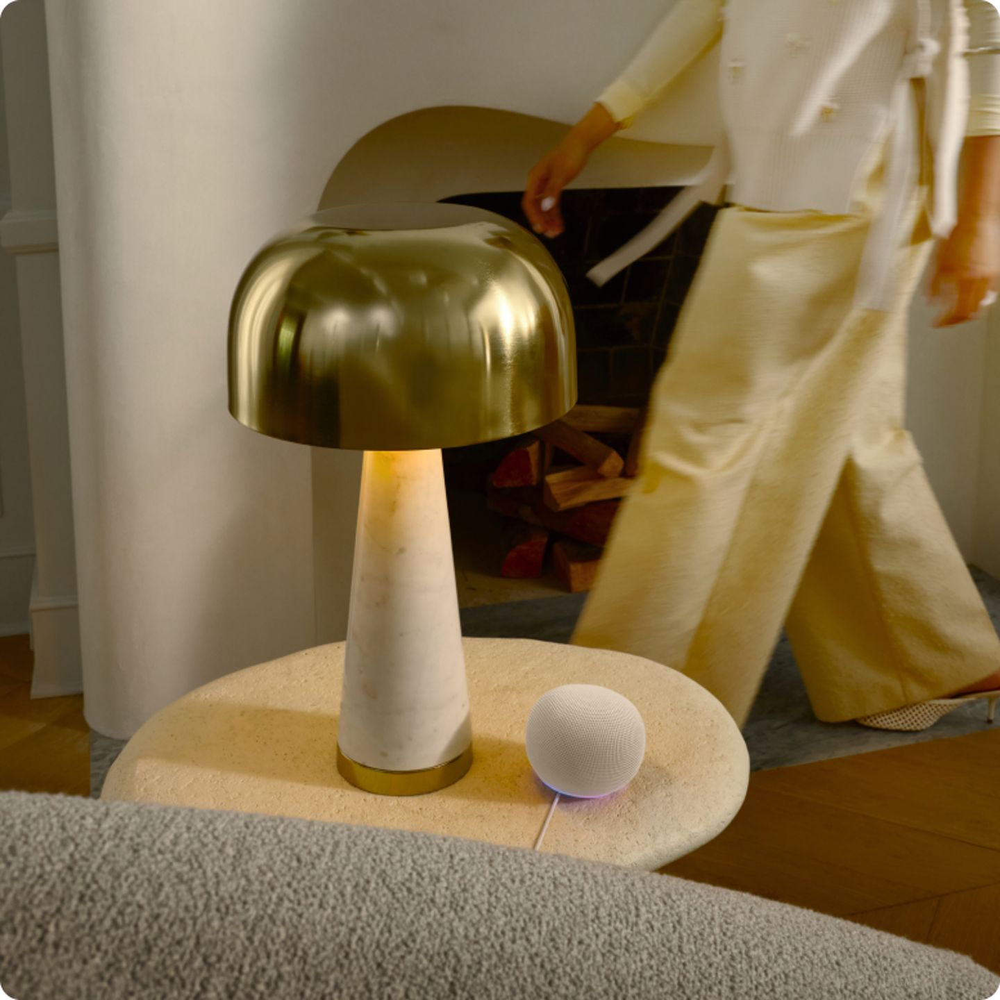 Moderne-lamp-met-gouden-kap-vrouw-in-lichte-kleding-ernaast.png