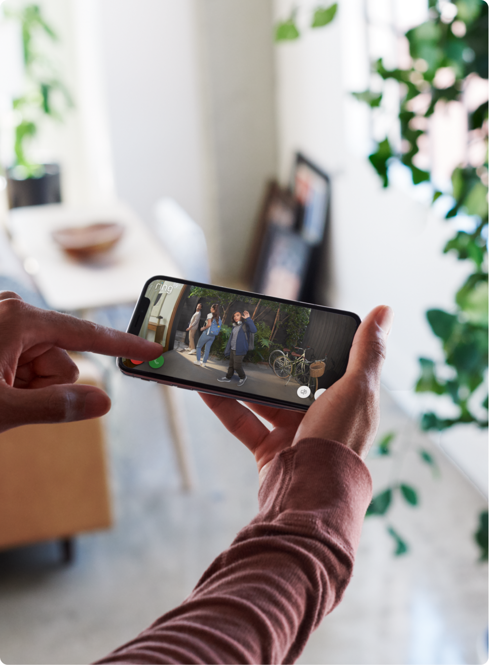 Hand-houdt-smartphone-met-video-van-mensen-in-de-tuin.png