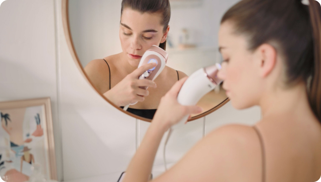 Vrouw_die_voor_de_spiegel_een_Braun_Smart_IPL_gebruikt.jpg