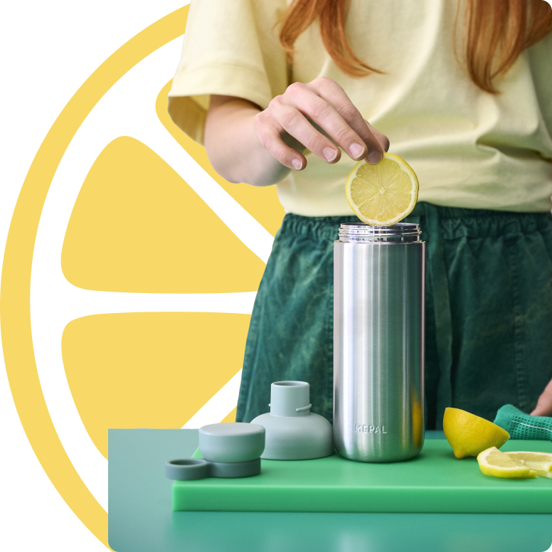 Vrouw-voegt-citroen-toe-aan-metalen-drinkfles-met-accessoires.png