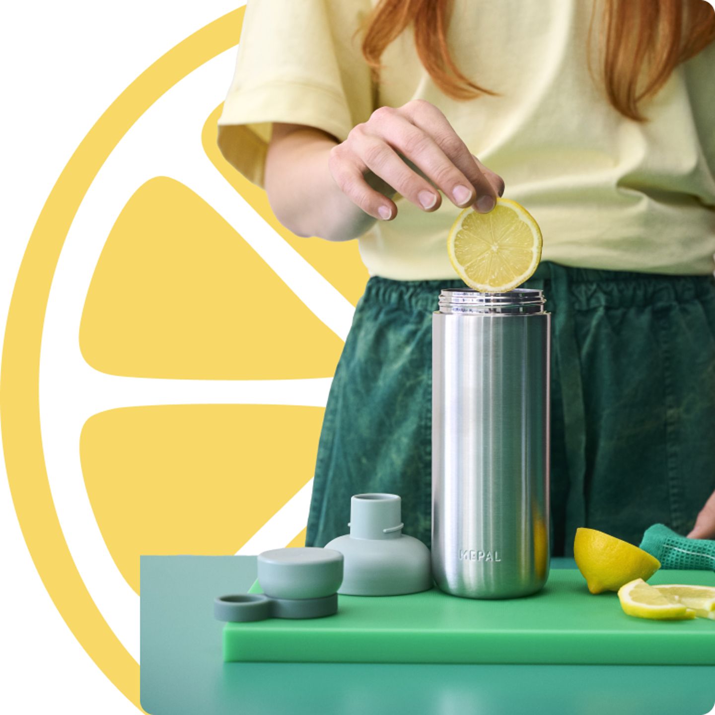 Vrouw-voegt-citroen-toe-aan-metalen-drinkfles-met-accessoires.png