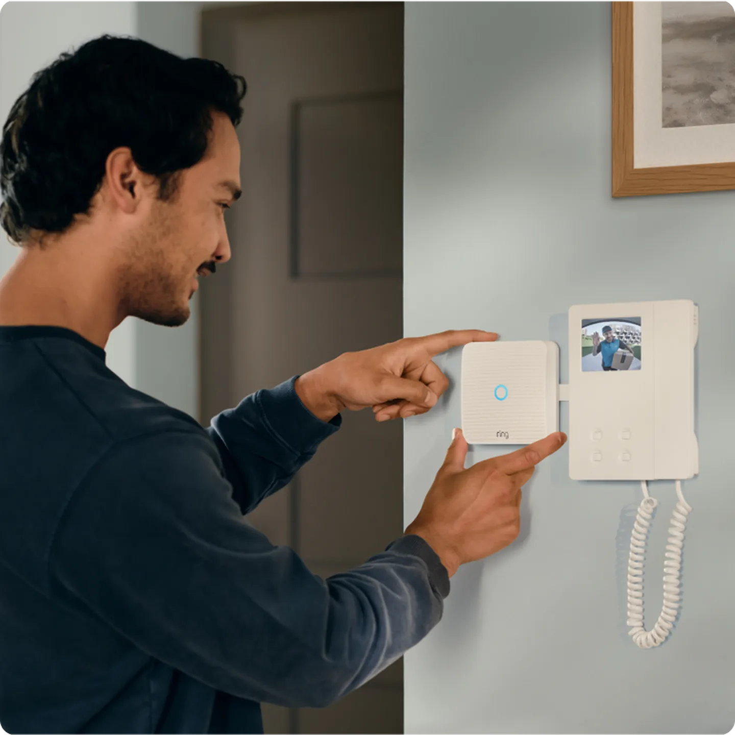 Man-bedient-videodeurbel-aan-de-muur-met-touchscreen.png