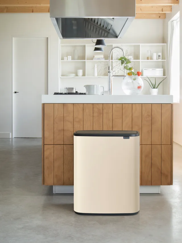 Beige prullenbak naast keukeneiland