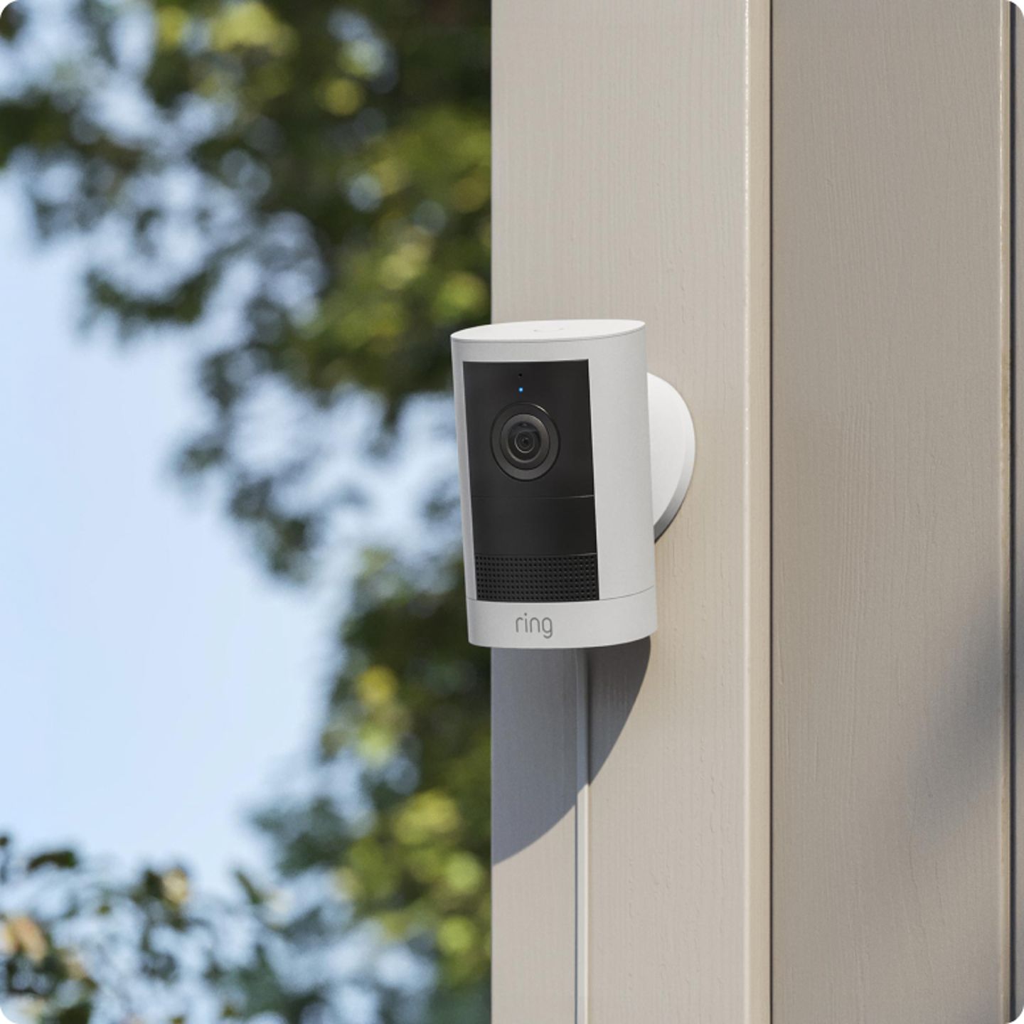 Witte-ringcamera-bevestigd-aan-een-houten-paal-buiten.png