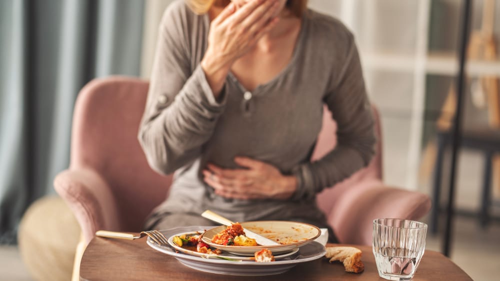 Mujer terminando de comer mucha comida