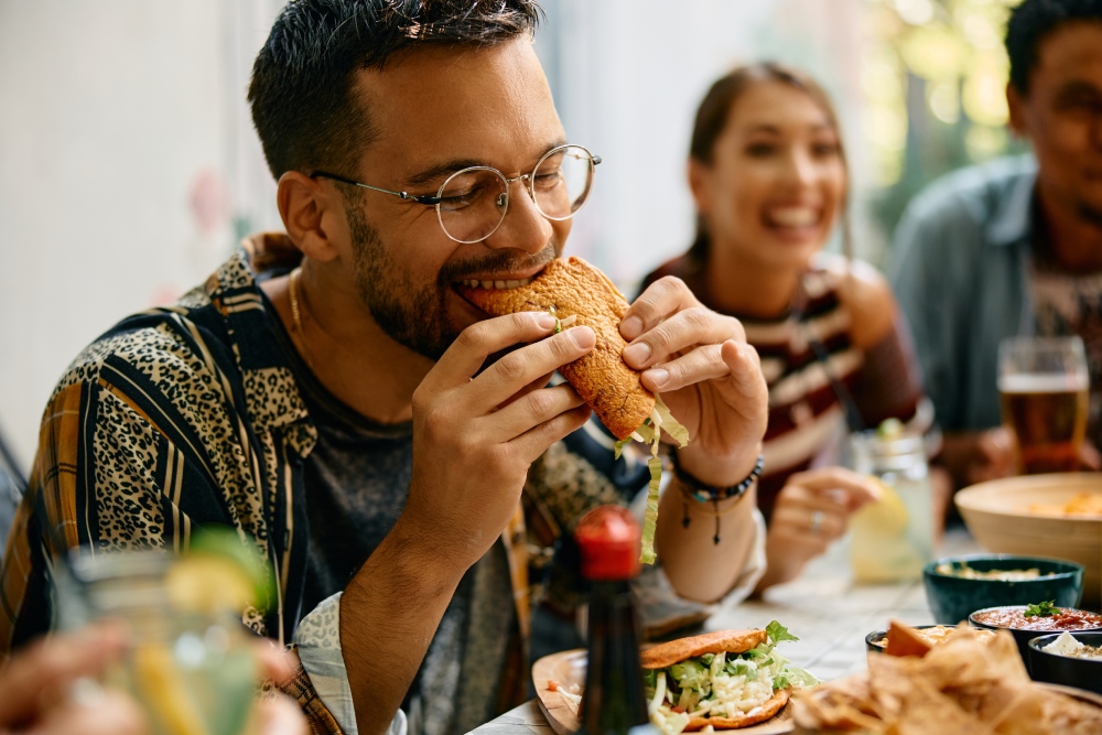 Hombre comiendo tacos en una reunión