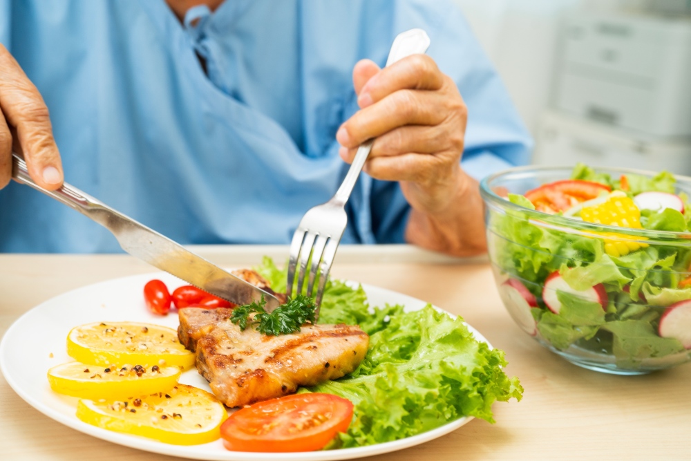Persona comiendo ensalada y pescado