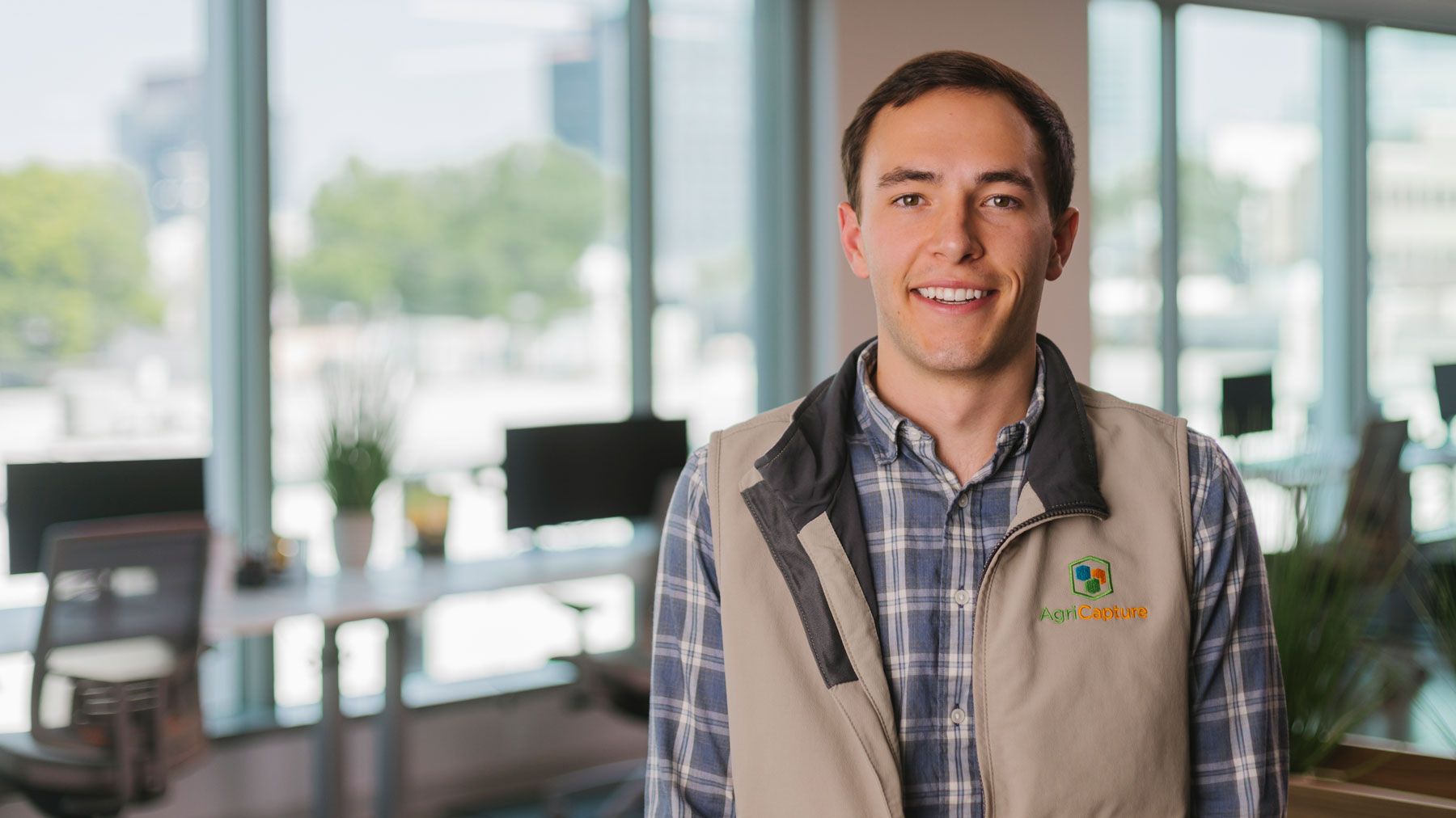 Man standing in a conference room facing the camera for a photo opportunity.