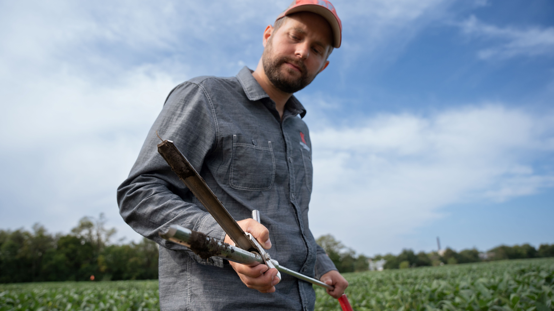 Dylan Mangel, assistant professor and Extension plant pathologist at UNL, collects a soil sample for soybean cyst nematode testing