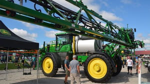 Farm show visitors gather around a John Deere sprayer on display Farm show visitors gather around a John Deere sprayer on display
