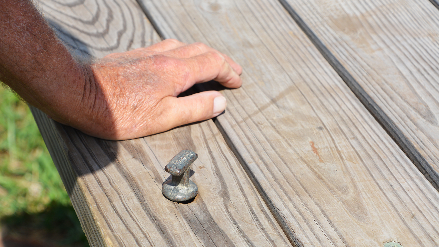 A hitch pin stuck in on a hole drilled into a wooden wagon bed