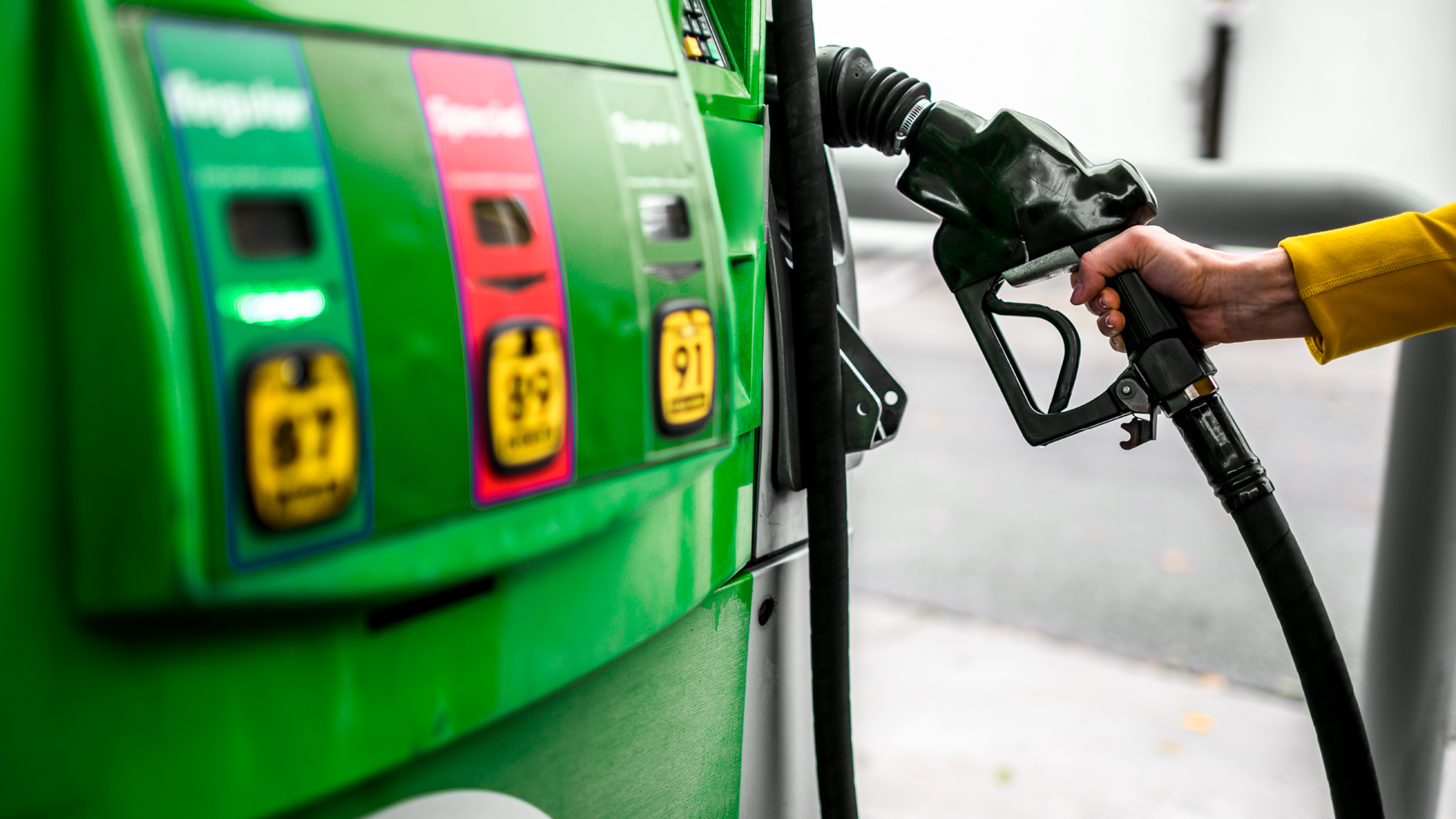 hand holding pump at gas station