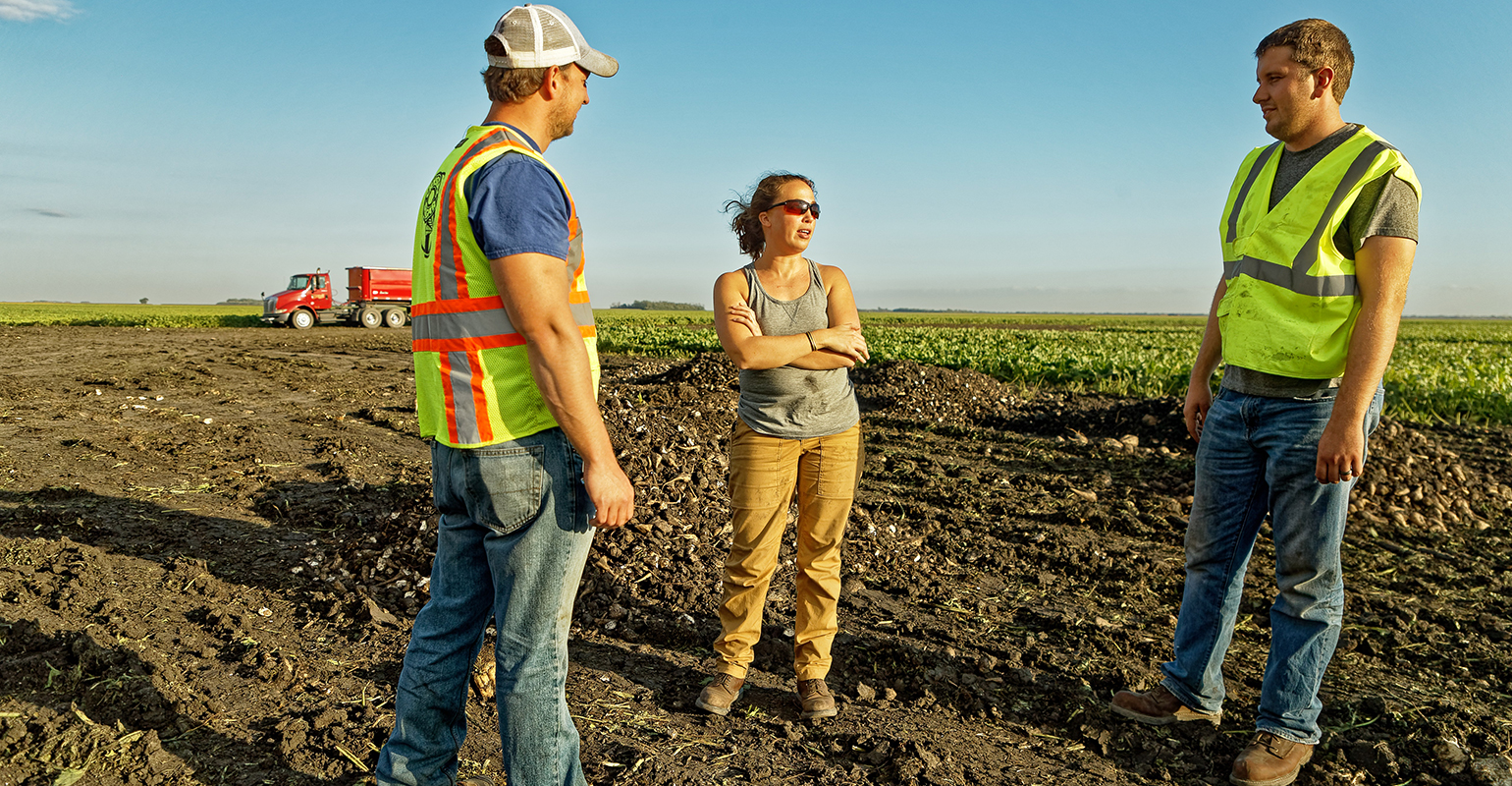American Crystal Sugar agriculturists Nick Shores (left) and Austin Holy (right) visited with grower Rachel Arneson 